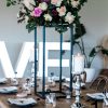 Black stand centerpieces on table with floral arrangement