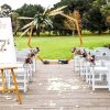 Classic wedding ceremony with heptagonal wedding arch in classic outdoor setting