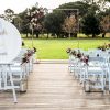 Modern wedding ceremony setting featuring gold arch and drunk in love signage