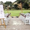 Garden wedding styling setting showing chairs, arch and signage