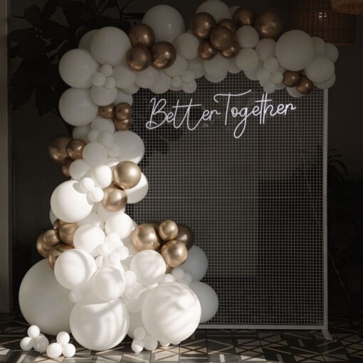 Better Together Neon hanging off a white mesh backdrop with balloons