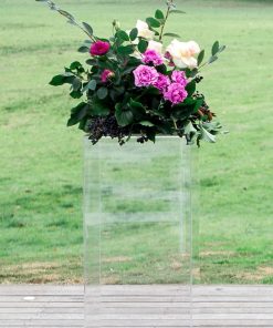 Clear ghost plinth stand with floral display on top