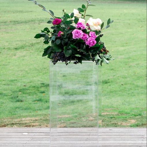 Clear ghost plinth stand with floral display on top