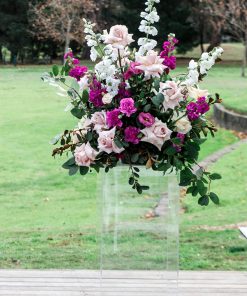 Clear plinth stand with floral arrangement