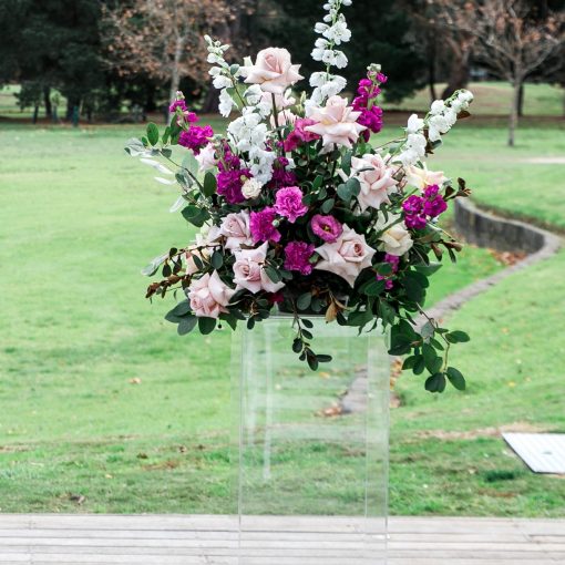 Clear plinth stand with floral arrangement