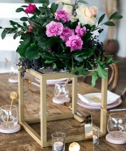 Gold cube metal centerpieces with flowers on table