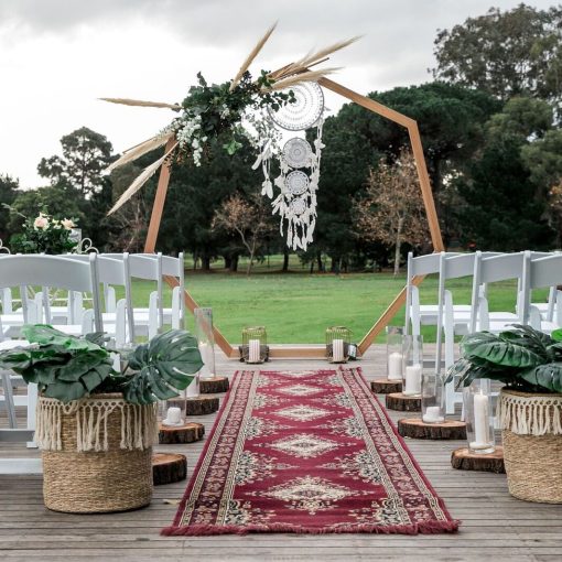 Heptagonal wedding arch in bohemian outdoor setting