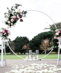 White Circular Wedding Arch with flowers on deck with candles and rose petals