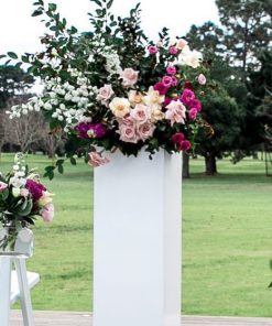 White plinth stand with floral arrangement