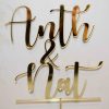 Mirrored gold cake topper saying Anth & Nat