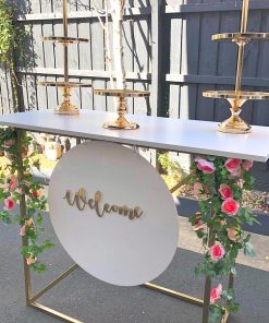 Dessert grazing table with gold welcome sign and cake stands