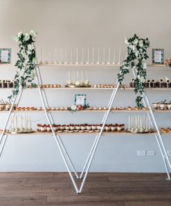 4 tier trestle style shelf adorned with numerous dessert offerings