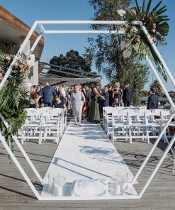 Hexagon arch framing wedding guests in background