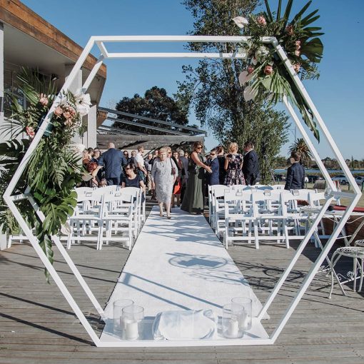 Hexagon arch framing wedding guests in background