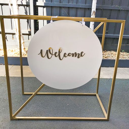 Welcome sign hanging from gold metal stand