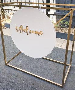 Welcome sign hanging from gold metal stand