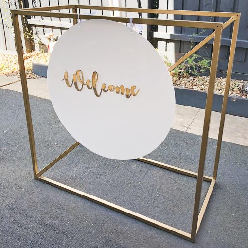 Welcome sign hanging from gold metal stand