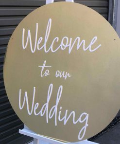 Gold wedding signage in circular gold sign with white scrip writing that says 