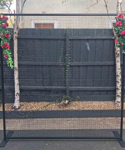 Black metal frame with flowers 2.3m square with mesh screen in middle standing in driveway