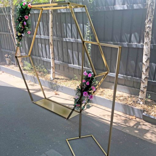 Gold metal hexagon arch and gold metal welcome stand in driveway