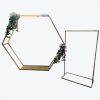 Gold metal arch with flowers and signage stand on white background