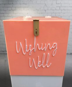 Front view of 300mm square blush pink acrylic wishing well box with white ‘wishing well’ acrylic script text on front and lock sitting on white plinth.