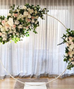 Garlands of flowers hanging on arch in front of curtain