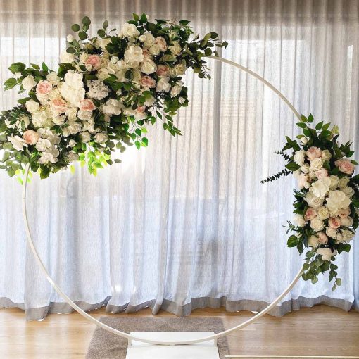 Garlands of flowers hanging on arch in front of curtain