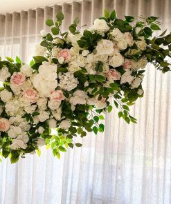 Garland of flowers hanging on arch in front of curtain