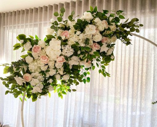 Garland of flowers hanging on arch in front of curtain