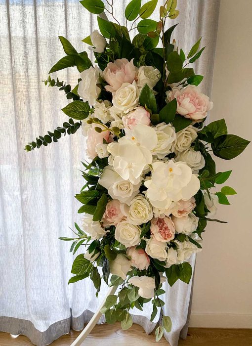 Garland of flowers hanging on arch in front of curtain