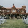 Garden wedding ceremony setup with white chairs and floral arch Melbourne